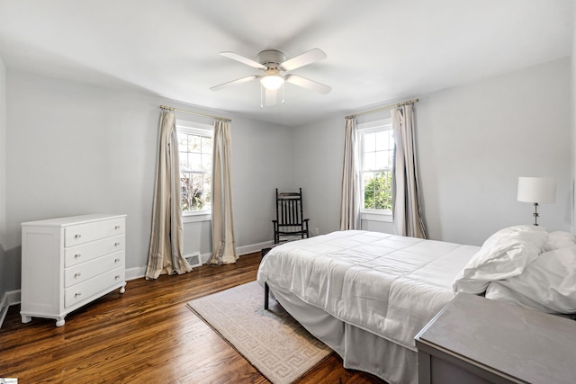 bedroom featuring dark wood-type flooring, a ceiling fan, and baseboards