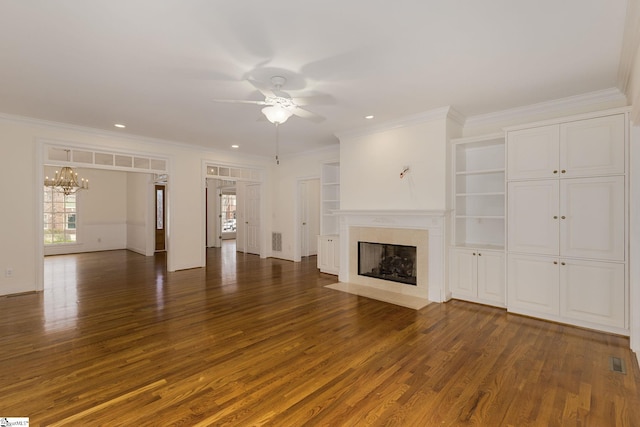 unfurnished living room with visible vents, a fireplace with flush hearth, ceiling fan with notable chandelier, wood finished floors, and crown molding