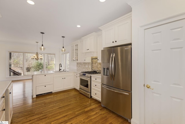 kitchen featuring dark wood finished floors, light countertops, stainless steel appliances, white cabinetry, and a sink