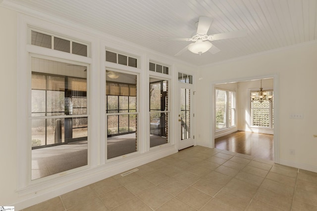 spare room featuring visible vents, ornamental molding, ceiling fan with notable chandelier, light tile patterned flooring, and baseboards