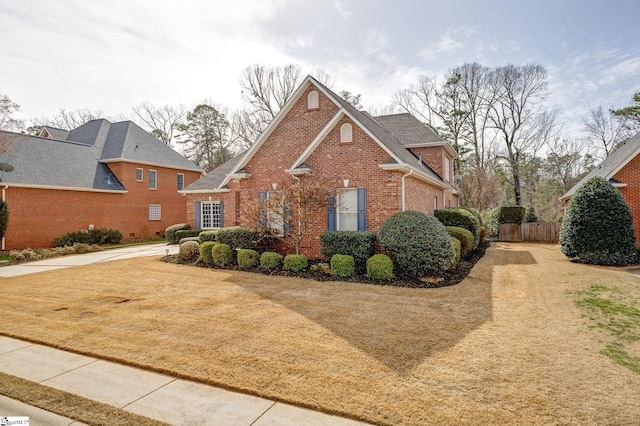 traditional-style home featuring fence and brick siding