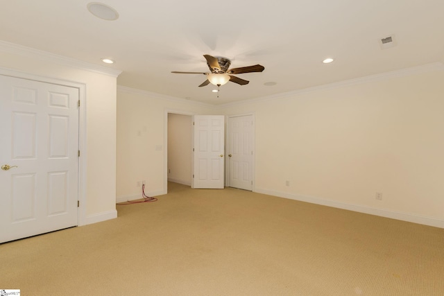 spare room with recessed lighting, light colored carpet, crown molding, and baseboards