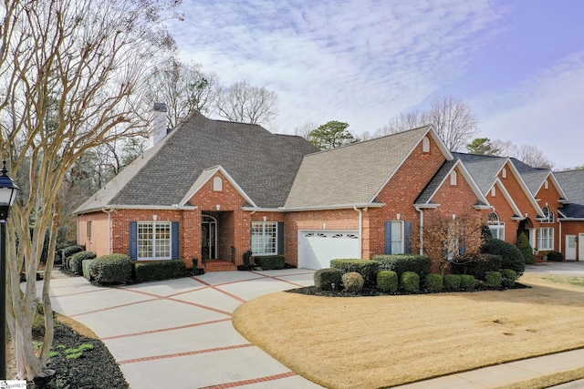 view of front facade featuring concrete driveway, an attached garage, a shingled roof, brick siding, and a chimney