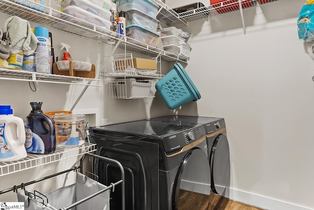 washroom with washer and dryer, laundry area, wood finished floors, and baseboards