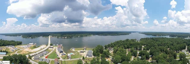 aerial view featuring a wooded view and a water view