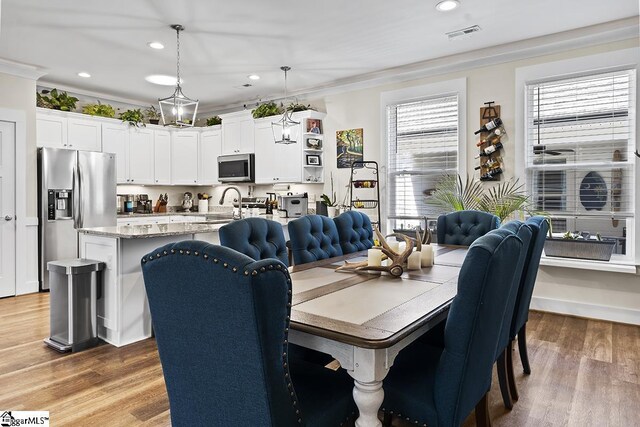 dining room with recessed lighting, wood finished floors, visible vents, and ornamental molding