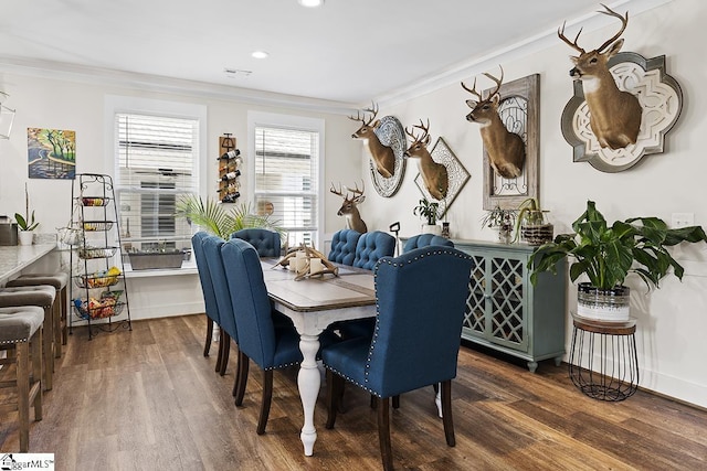 dining room with visible vents, baseboards, dark wood finished floors, and crown molding