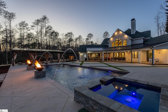 outdoor pool featuring a fire pit, an in ground hot tub, and a patio area