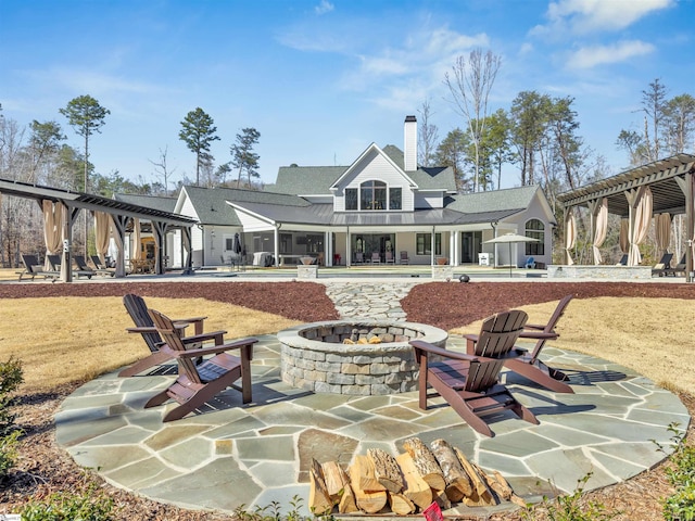 rear view of house featuring a fire pit, a patio, and a pergola