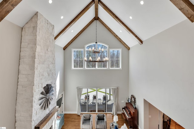 living room featuring beam ceiling, high vaulted ceiling, a wealth of natural light, and an inviting chandelier