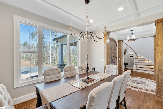 dining space featuring stairway, a notable chandelier, wood finished floors, and a healthy amount of sunlight