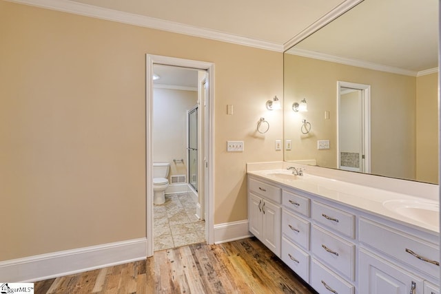 full bath with a sink, toilet, wood finished floors, and crown molding