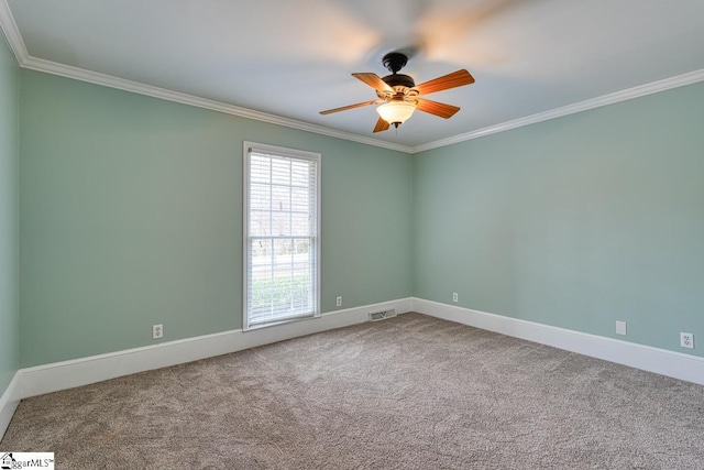 spare room with a ceiling fan, baseboards, carpet, visible vents, and ornamental molding