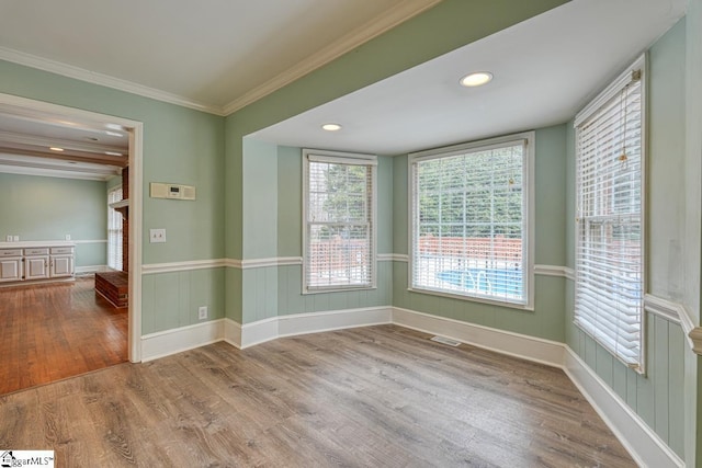 unfurnished room with visible vents, crown molding, recessed lighting, wainscoting, and wood finished floors