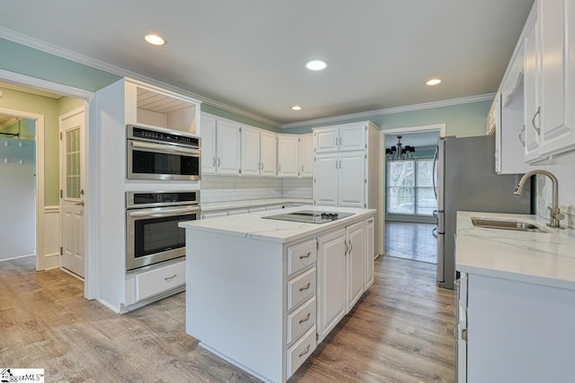 kitchen with light wood-style floors, black electric stovetop, double oven, and a center island