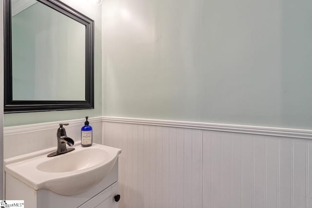 bathroom with a wainscoted wall and vanity