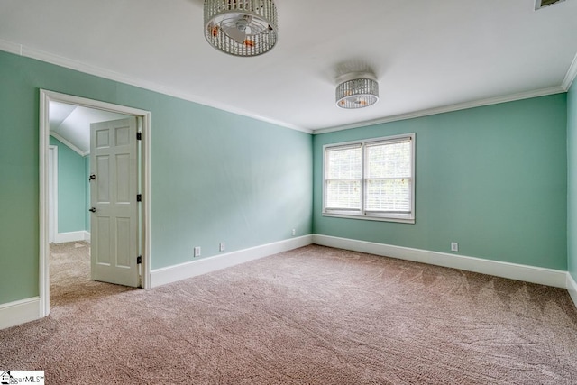 empty room featuring visible vents, baseboards, carpet, and ornamental molding