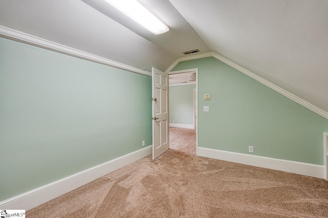 additional living space featuring vaulted ceiling, carpet, baseboards, and visible vents