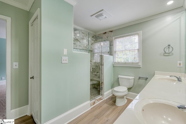 bathroom with visible vents, a shower stall, toilet, ornamental molding, and a sink