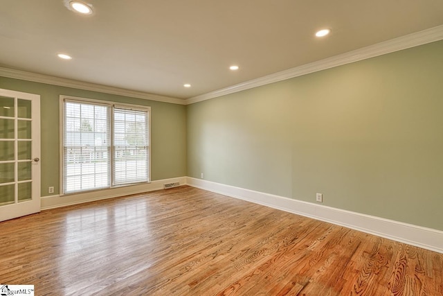 spare room with baseboards, visible vents, recessed lighting, ornamental molding, and light wood-style floors