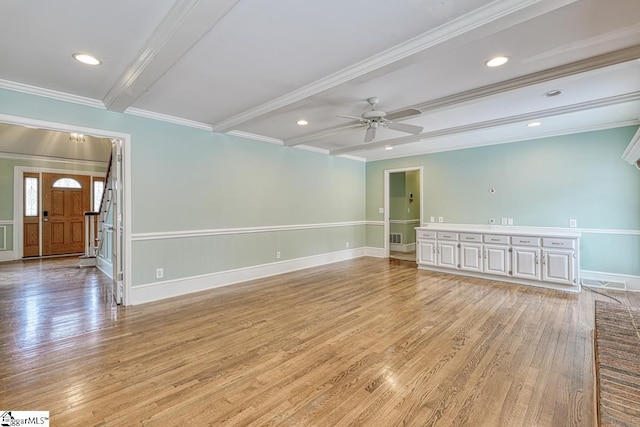 spare room featuring beam ceiling, light wood-type flooring, ceiling fan, and ornamental molding