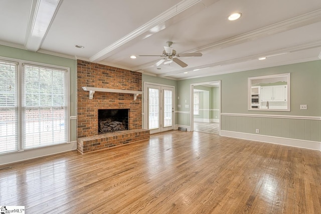 unfurnished living room with beam ceiling, a healthy amount of sunlight, and light wood-style floors