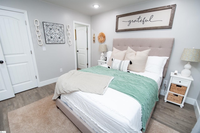 bedroom with wood finished floors and baseboards