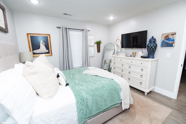 bedroom with recessed lighting, visible vents, baseboards, and wood finished floors