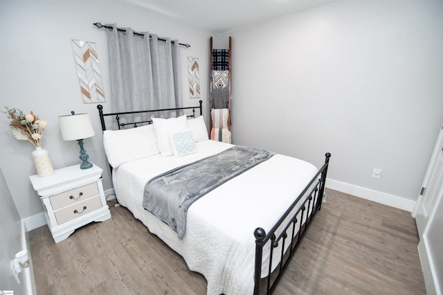 bedroom with baseboards and wood finished floors