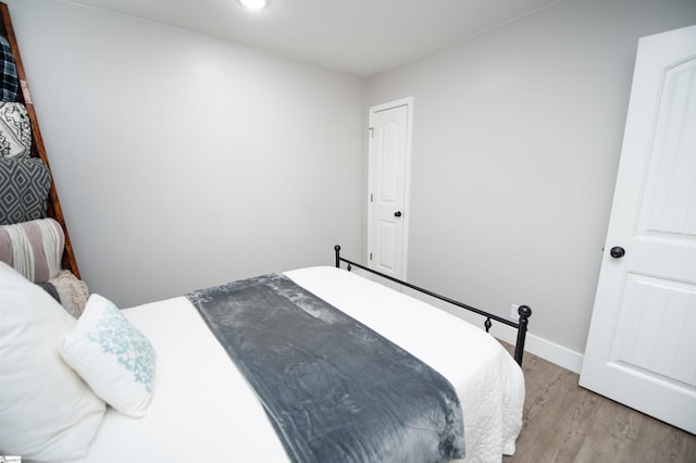 bedroom with light wood-type flooring and baseboards