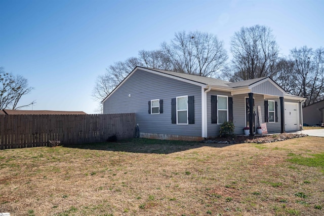 view of home's exterior featuring a lawn, a garage, and fence