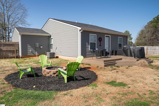 rear view of property featuring an outdoor fire pit, central AC, a deck, and fence