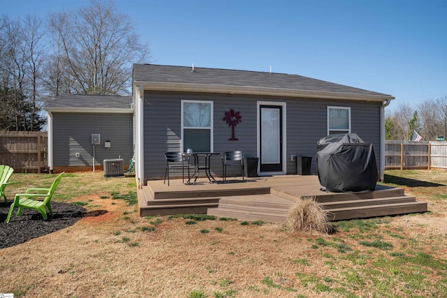 back of house with central air condition unit, fence, a lawn, and a wooden deck