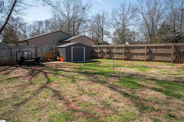 view of yard with a storage shed, a fenced backyard, and an outdoor structure