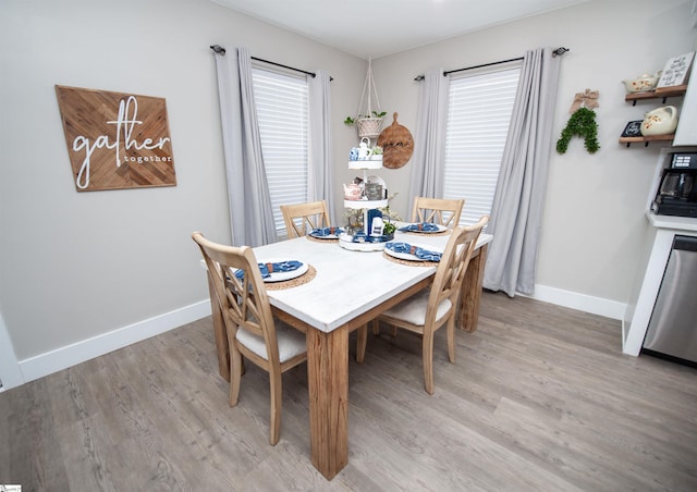 dining area with a wealth of natural light, baseboards, and light wood finished floors