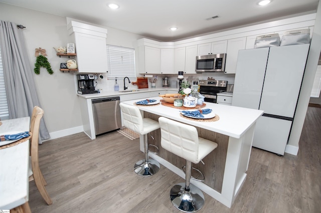 kitchen featuring a sink, light countertops, light wood-style floors, and stainless steel appliances