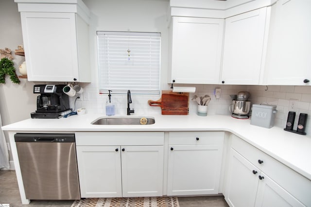 kitchen featuring a sink, dishwasher, light countertops, and white cabinetry