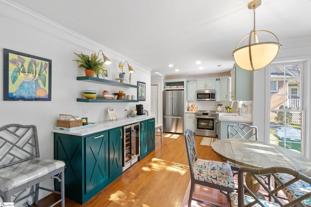 dining space featuring wine cooler, a dry bar, ornamental molding, recessed lighting, and light wood-style floors