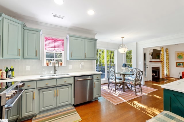 kitchen featuring a sink, appliances with stainless steel finishes, wood finished floors, and light countertops