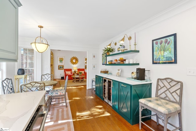 dining room with baseboards, light wood finished floors, ornamental molding, wine cooler, and a dry bar