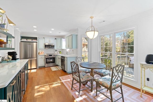 dining space featuring light wood finished floors, visible vents, recessed lighting, and ornamental molding