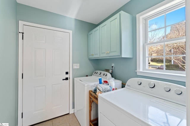 laundry room with light tile patterned floors, cabinet space, and washer and clothes dryer