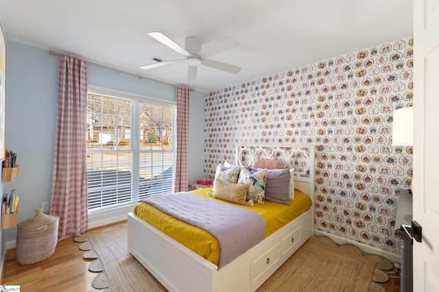 bedroom featuring a ceiling fan, wood finished floors, and visible vents