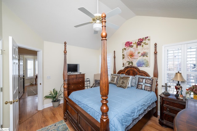 bedroom featuring baseboards, lofted ceiling, ceiling fan, and light wood finished floors