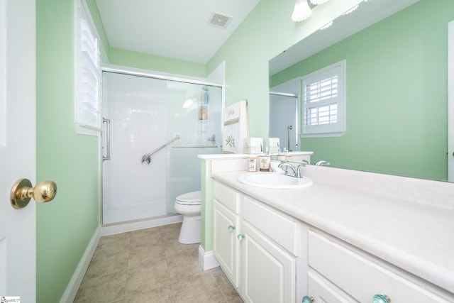 bathroom with vanity, baseboards, visible vents, a shower stall, and toilet