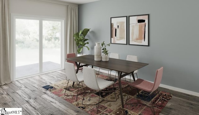 dining space with baseboards and wood finished floors