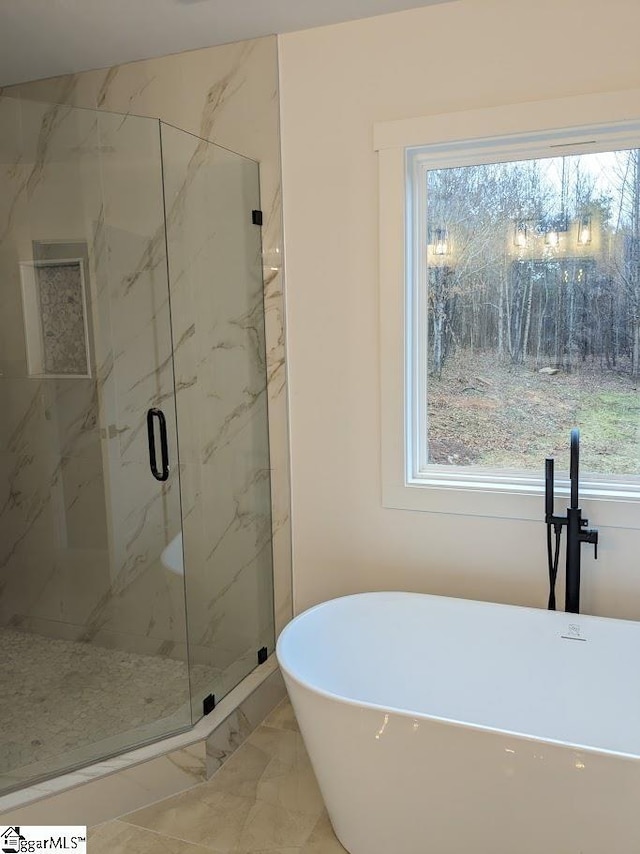 full bath with a marble finish shower, a soaking tub, and marble finish floor