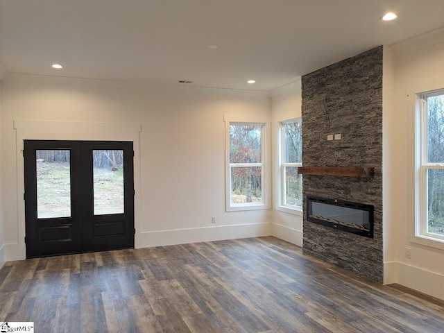 foyer with dark wood-style floors, recessed lighting, a fireplace, and french doors