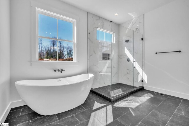 bathroom featuring recessed lighting, a marble finish shower, baseboards, and a soaking tub