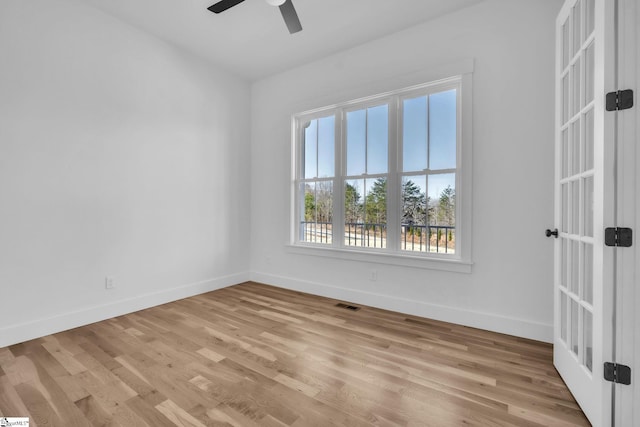 empty room with ceiling fan, visible vents, baseboards, and light wood-style flooring